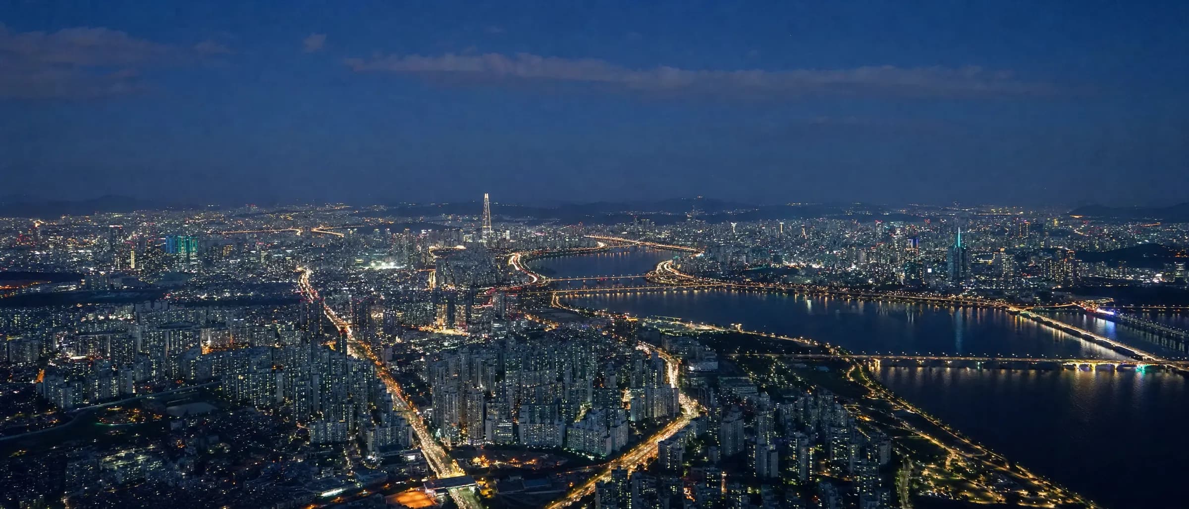 夕暮れ時、明かりが灯ったソウル市内の空撮写真